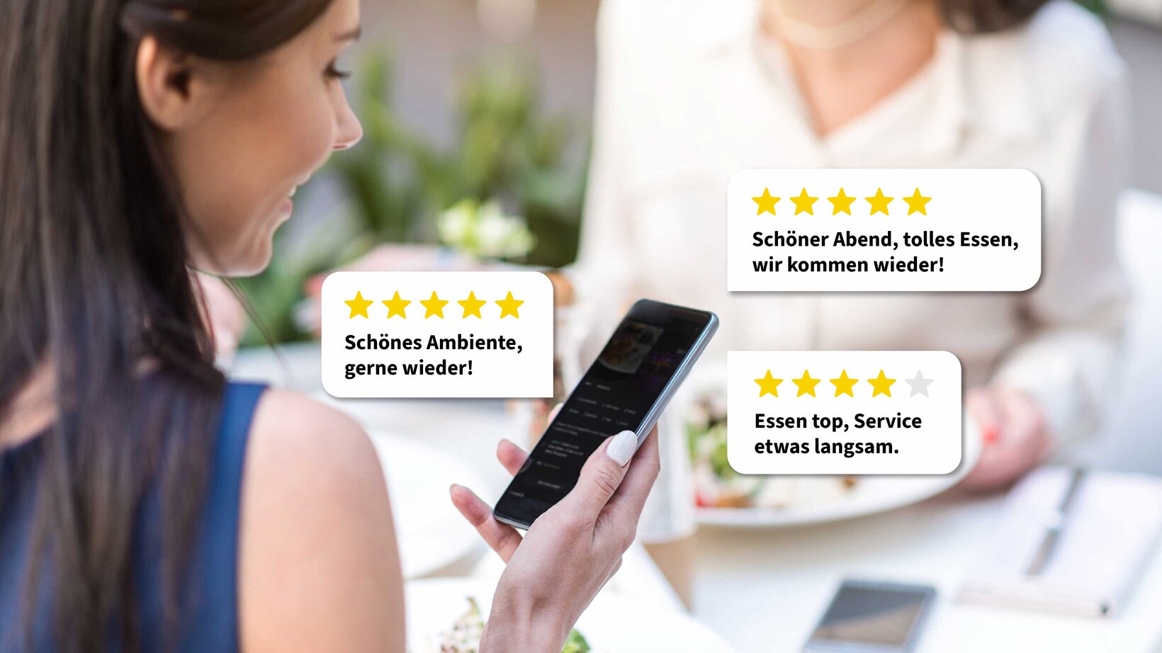 Drei Gästebewertungen als Sprechblasen mit Sternen vor einer Person mit Smartphone im Restaurant als Symbol fürs Beantworten von Google-Rezensionen