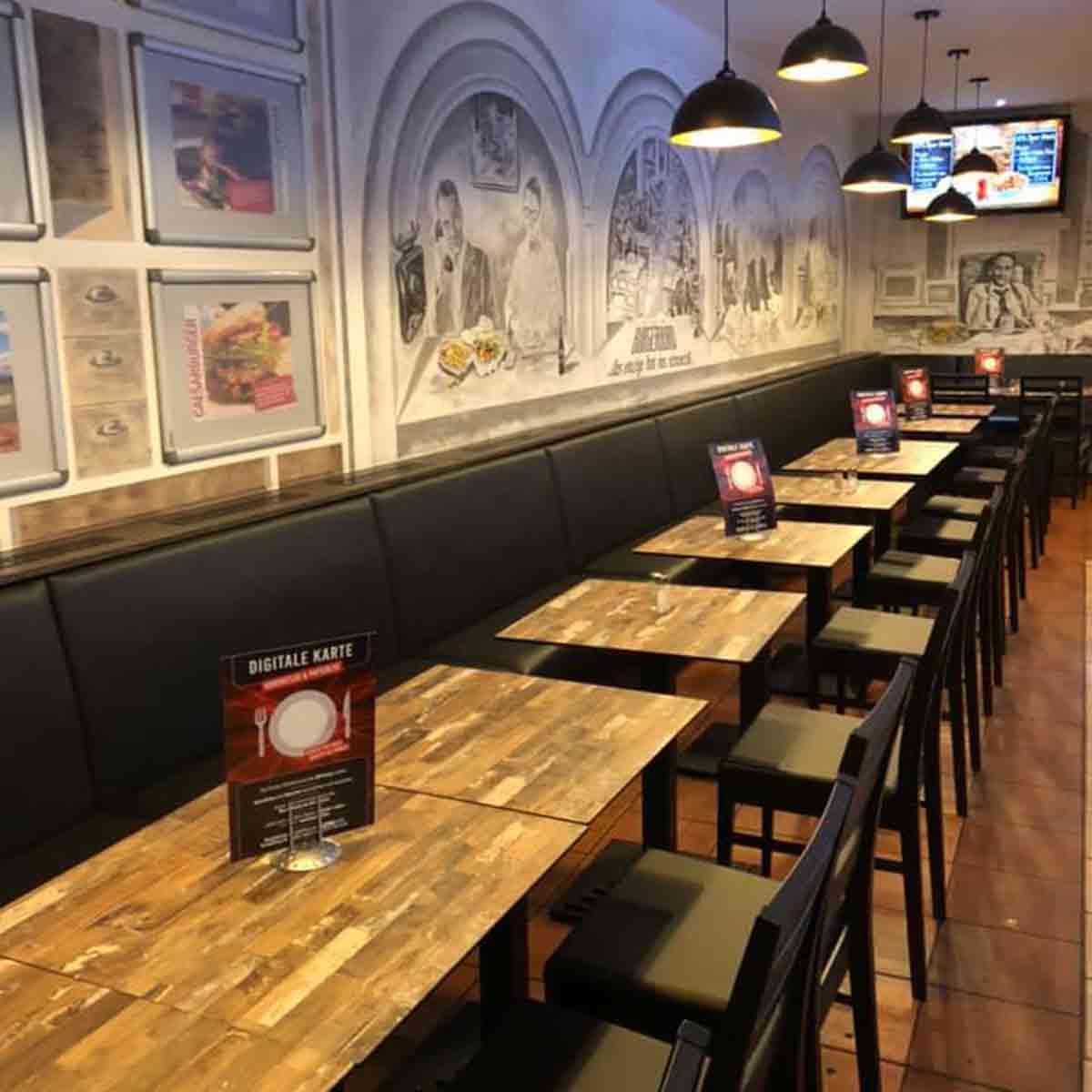 Tischaufsteller mit der digitalen Speisekarte im Innenraum eines Redo-Restaurants